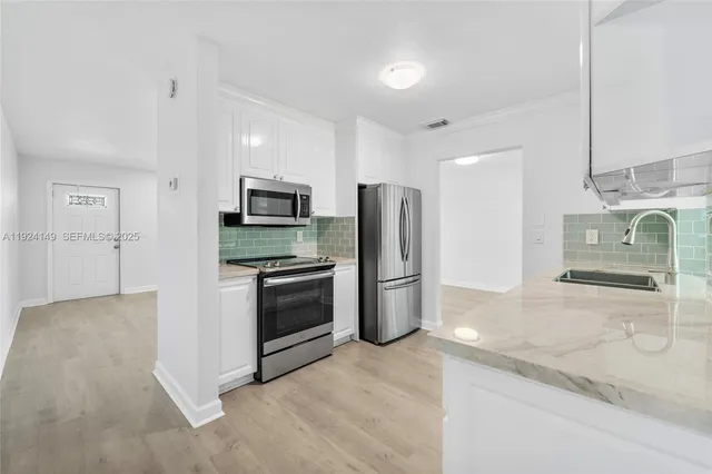 a kitchen with stainless steel appliances granite countertop a refrigerator and a stove