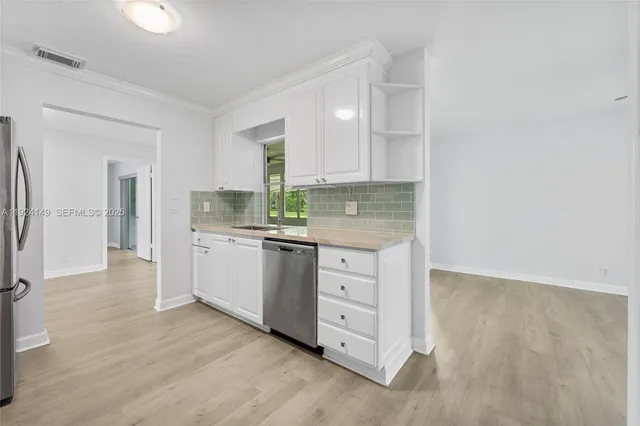 a kitchen with granite countertop white cabinets and white appliances