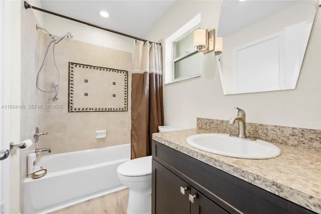 a bathroom with a granite countertop sink a mirror a shower and a bathtub