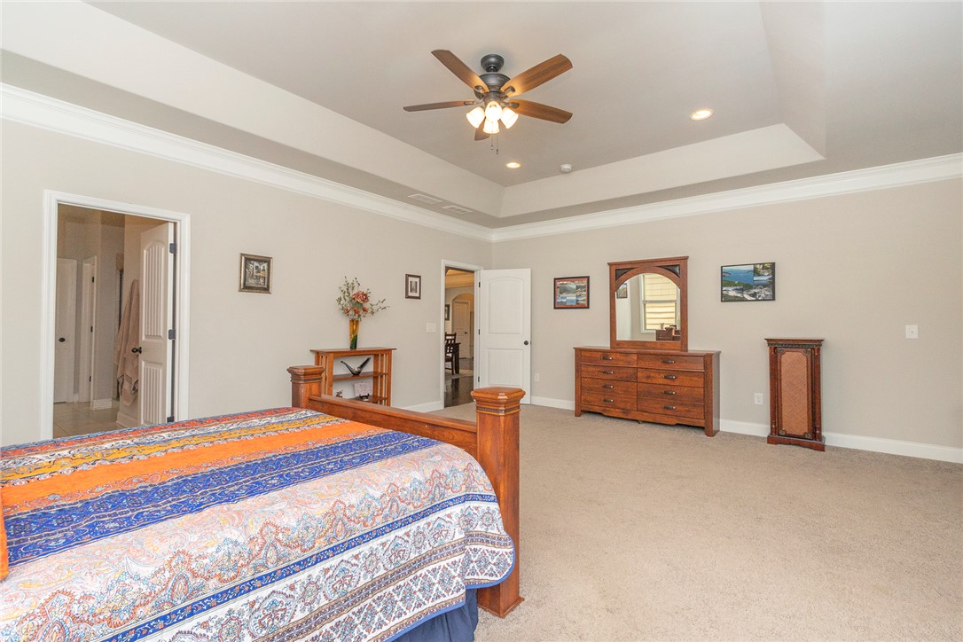 22 Old American Boulevard Pendleton, SC 29670 - Photo 15 of 49 This spacious bedroom features a ceiling fan, plush carpet, and elegant tray ceiling for elevated comfort.