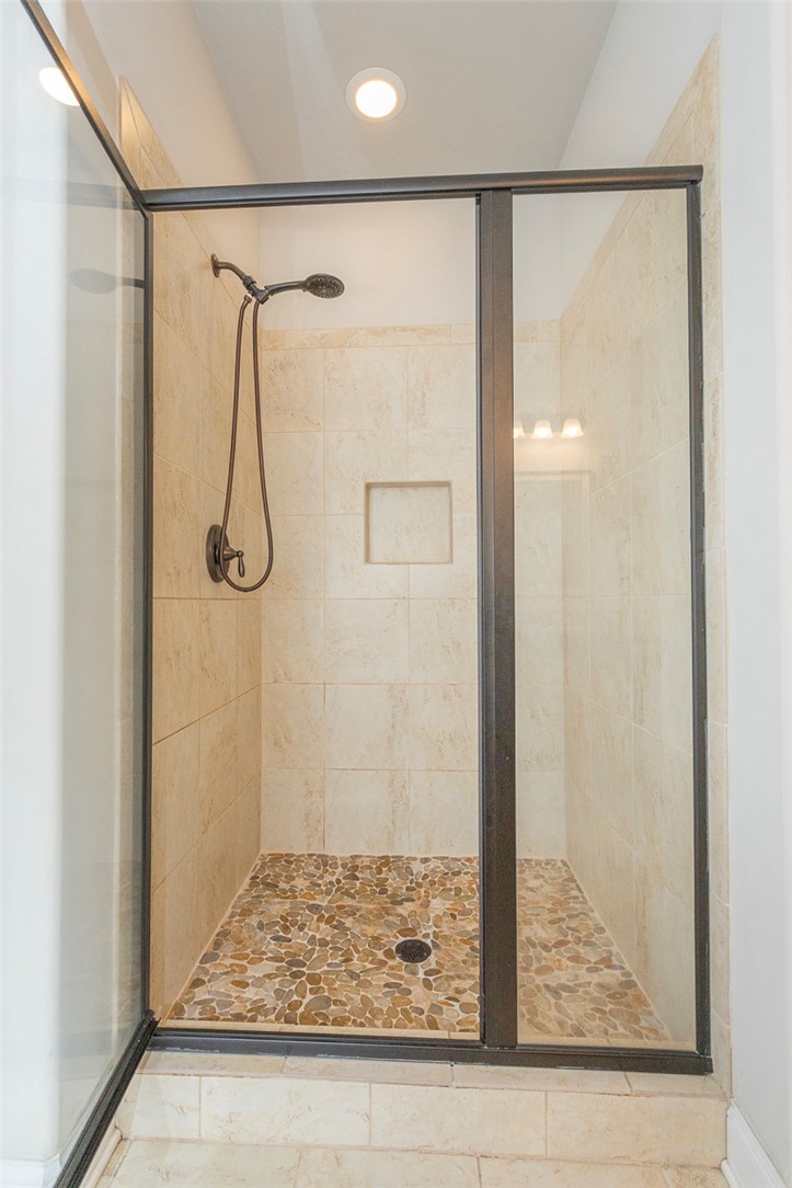 22 Old American Boulevard Pendleton, SC 29670 - Photo 17 of 49 This bathroom features a contemporary walk-in shower with a unique pebble floor and tiled walls.