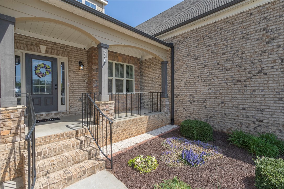 22 Old American Boulevard Pendleton, SC 29670 - Photo 2 of 49 The home showcases a beautiful brick exterior with a welcoming porch and vibrant landscaping.