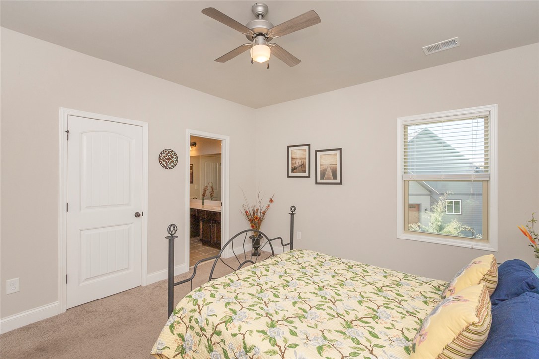 22 Old American Boulevard Pendleton, SC 29670 - Photo 23 of 49 This cozy bedroom features a ceiling fan, a window, and convenient access to an en-suite bathroom.