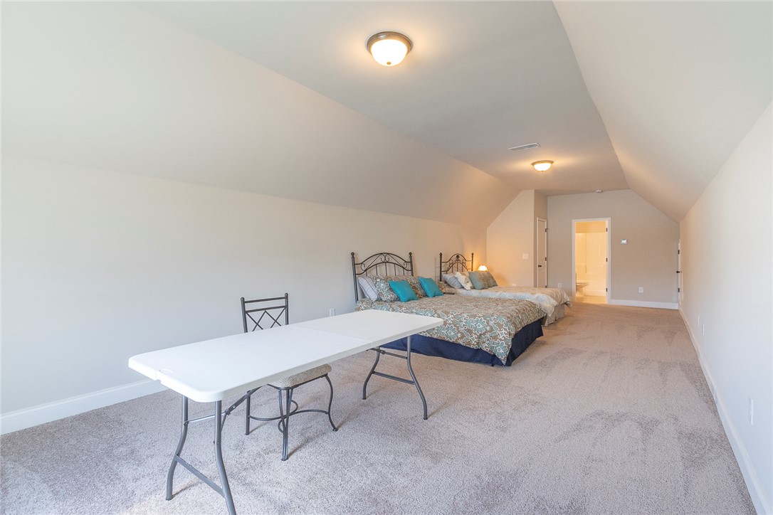 22 Old American Boulevard Pendleton, SC 29670 - Photo 28 of 49 This spacious bedroom offers ample space with carpet flooring and sloped ceilings.