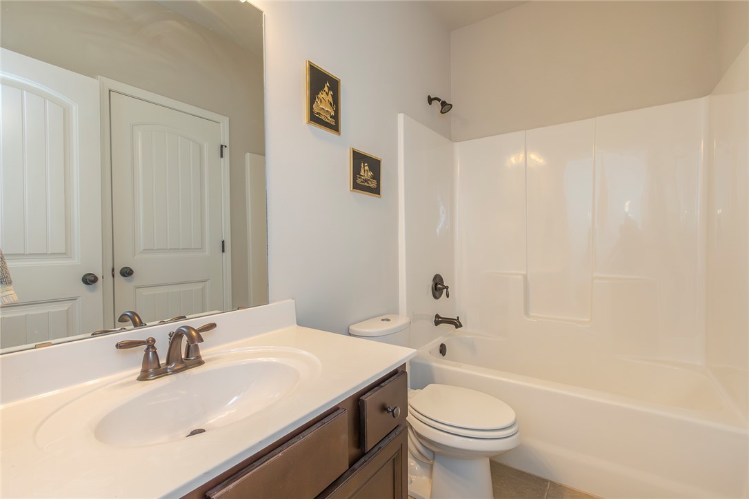 22 Old American Boulevard Pendleton, SC 29670 - Photo 29 of 49 This bright bathroom features a single vanity, a toilet, and a bathtub with a shower.