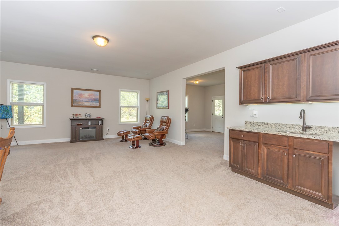 22 Old American Boulevard Pendleton, SC 29670 - Photo 32 of 49 An inviting family room boasts plush carpeting and a convenient wet bar for effortless entertaining.