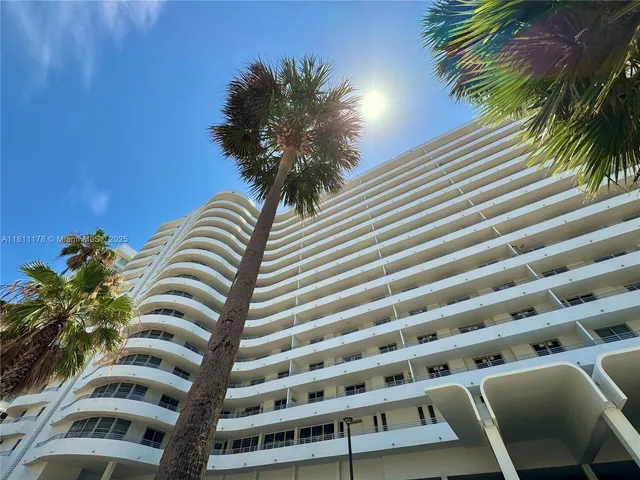 a view of a balcony with plants and palm trees