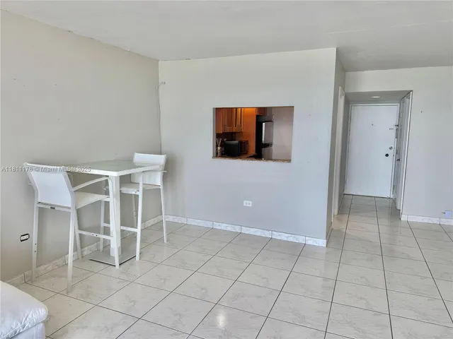 a view of an empty room with wooden floor and cabinets