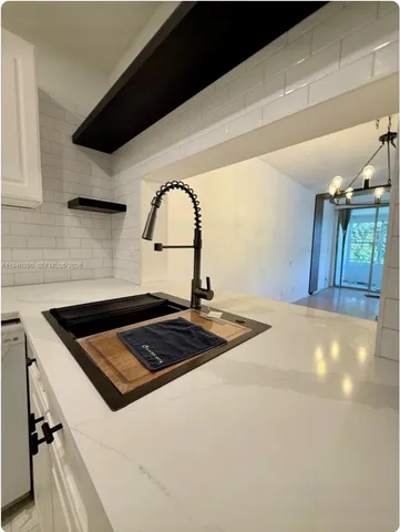 a kitchen with a sink a stove and cabinets
