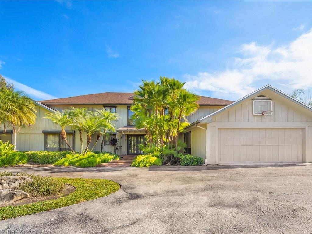 154 Cajeput Drive Naples, FL 34108 - Photo 18 of 45 a front view of a house with garden