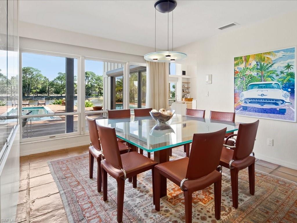 154 Cajeput Drive Naples, FL 34108 - Photo 26 of 45 a dining room with furniture a chandelier and wooden floor
