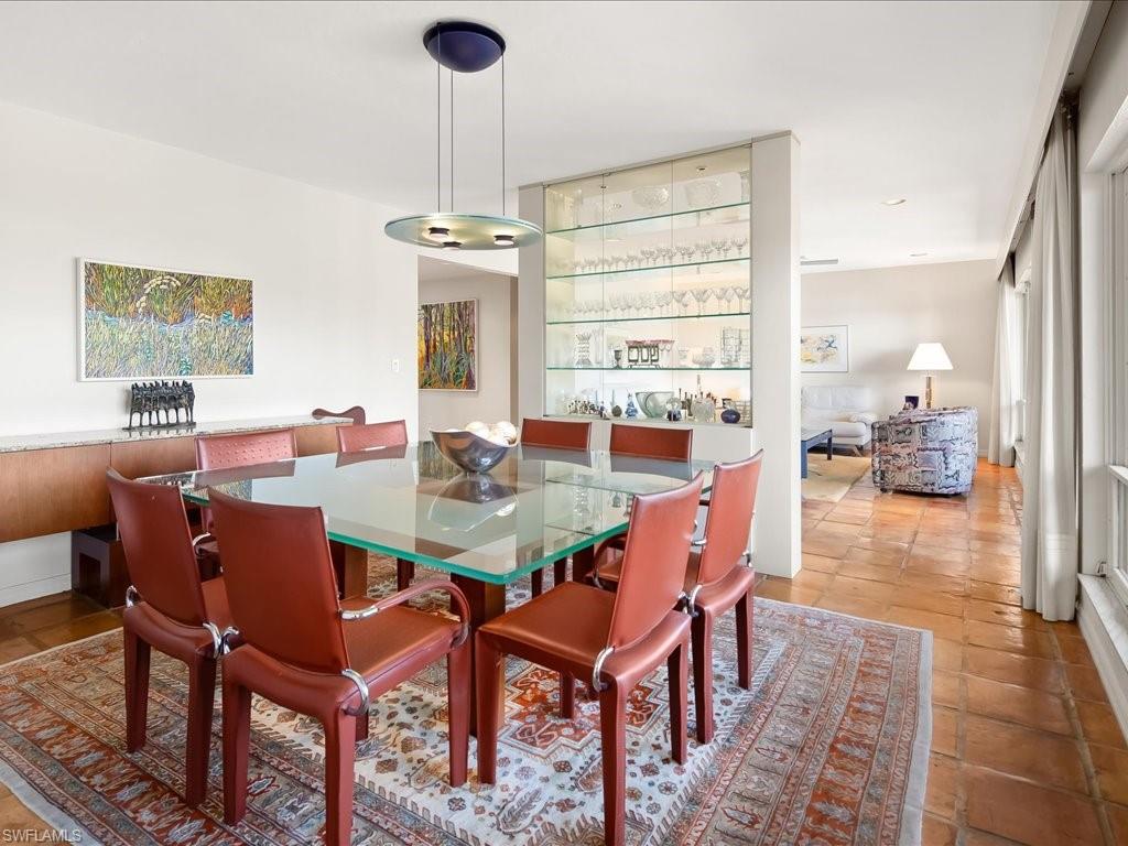 154 Cajeput Drive Naples, FL 34108 - Photo 27 of 45 a view of a dining room with furniture wooden floor and a chandelier