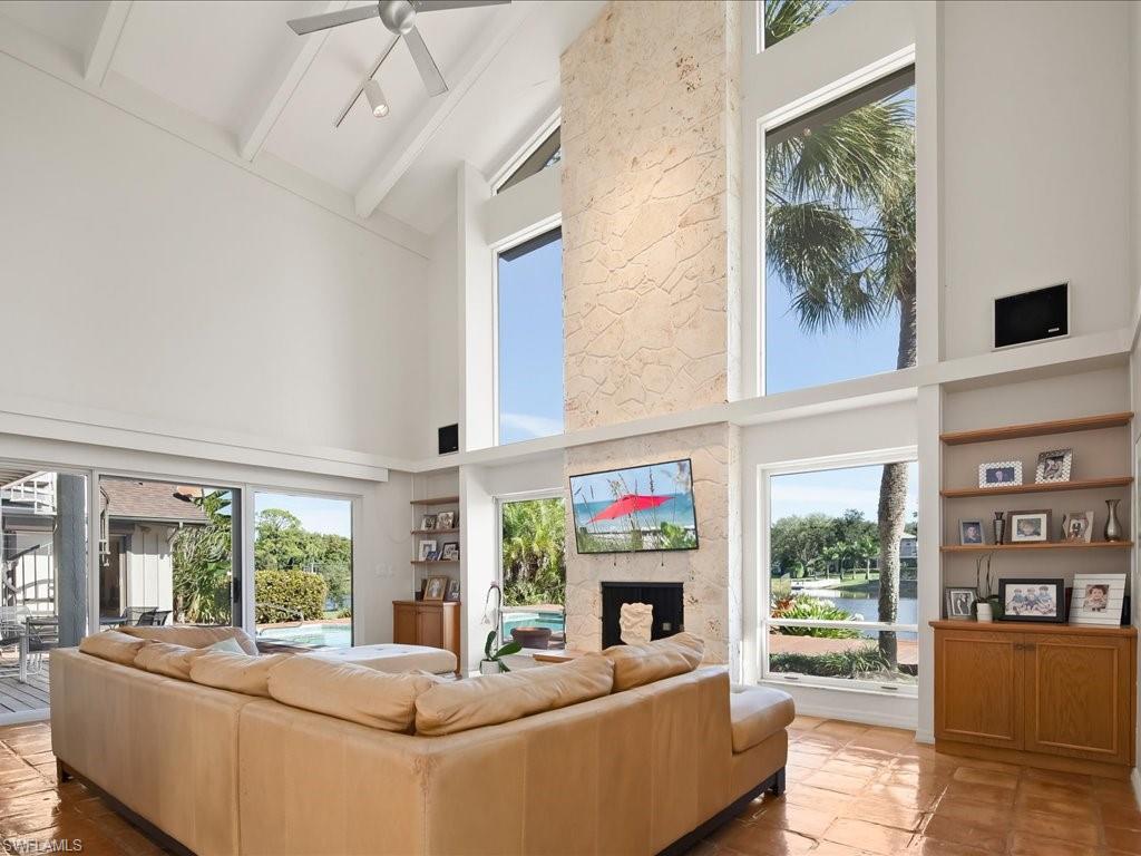 154 Cajeput Drive Naples, FL 34108 - Photo 31 of 45 a living room with fireplace furniture and a floor to ceiling window