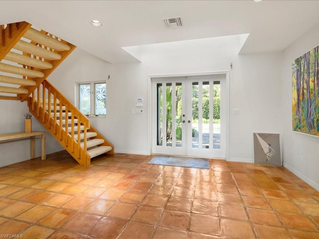 154 Cajeput Drive Naples, FL 34108 - Photo 32 of 45 a view of an empty room with windows & lounge chair