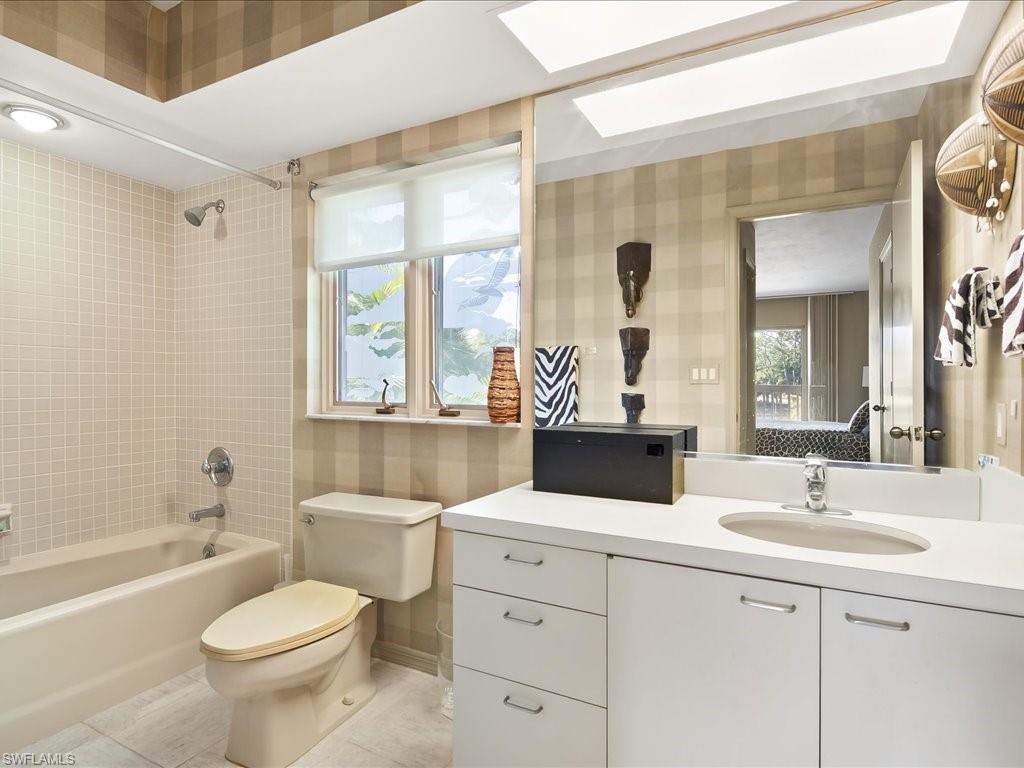154 Cajeput Drive Naples, FL 34108 - Photo 44 of 45 a bathroom with a toilet a sink a mirror a bathtub and vanity