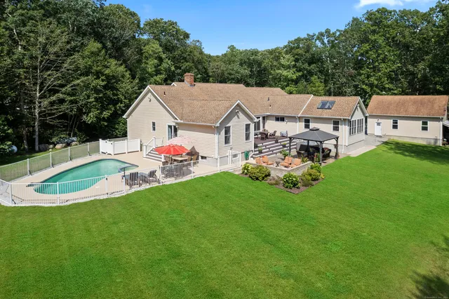 a aerial view of a house with a yard table and chairs