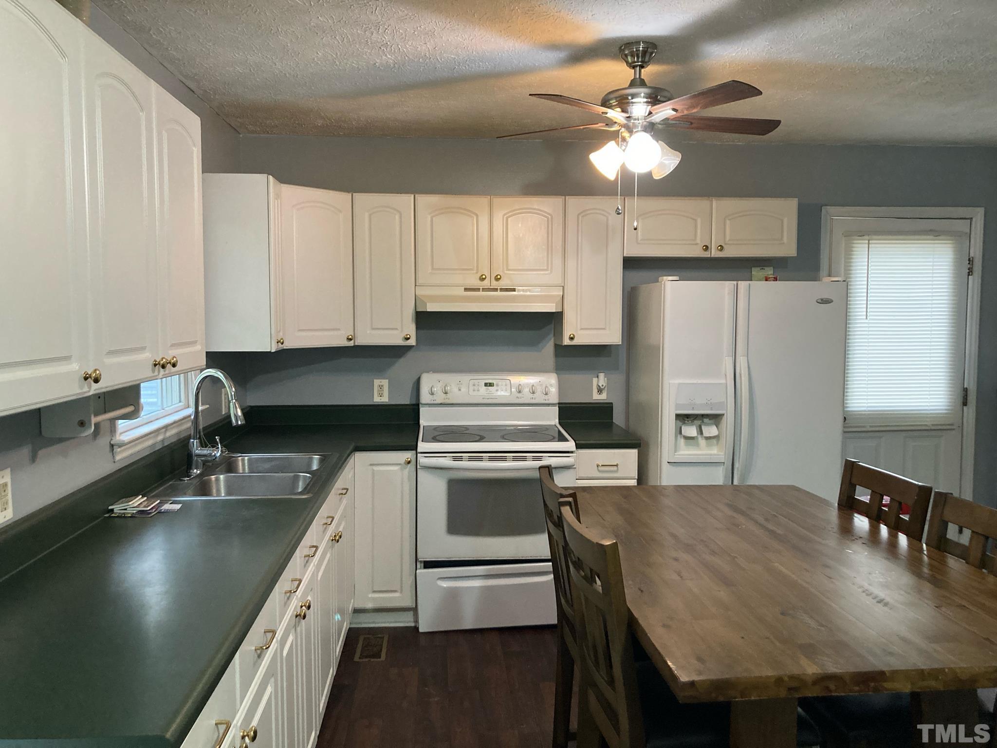 5924 Virgilina Road Roxboro, NC 27574 - Photo 3 of 6 a kitchen with stainless steel appliances granite countertop a sink a stove and refrigerator