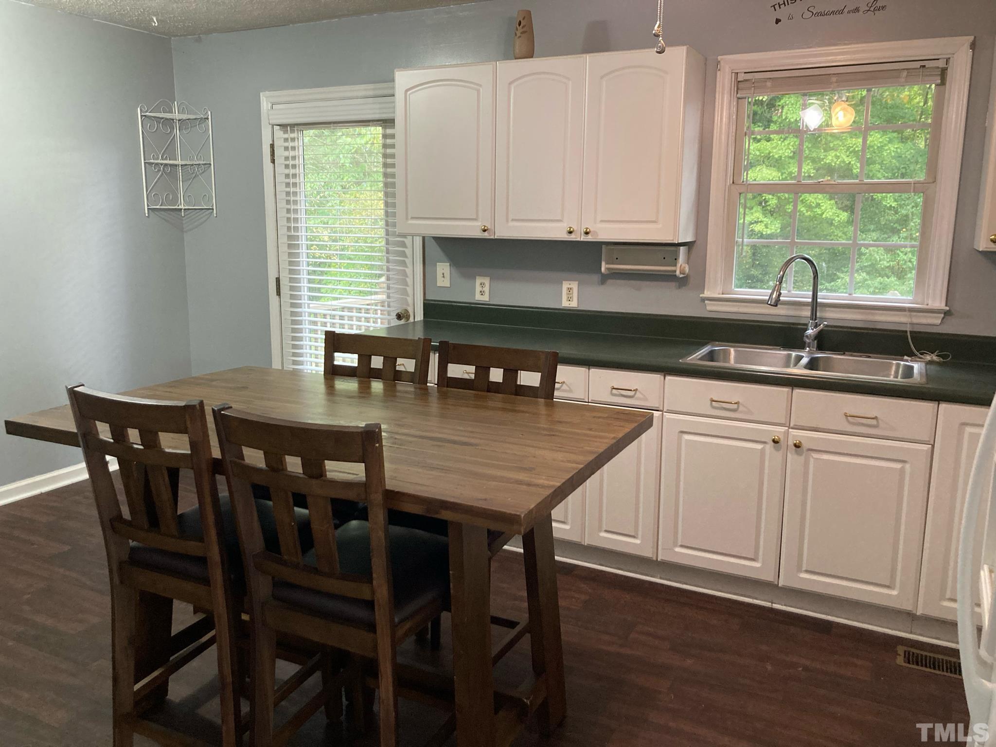 5924 Virgilina Road Roxboro, NC 27574 - Photo 5 of 6 a kitchen with granite countertop a table chairs sink and cabinets