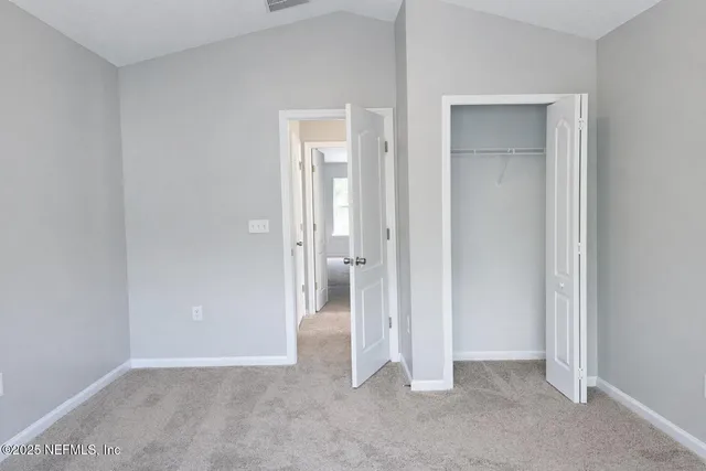 an empty room with closet and a bathroom