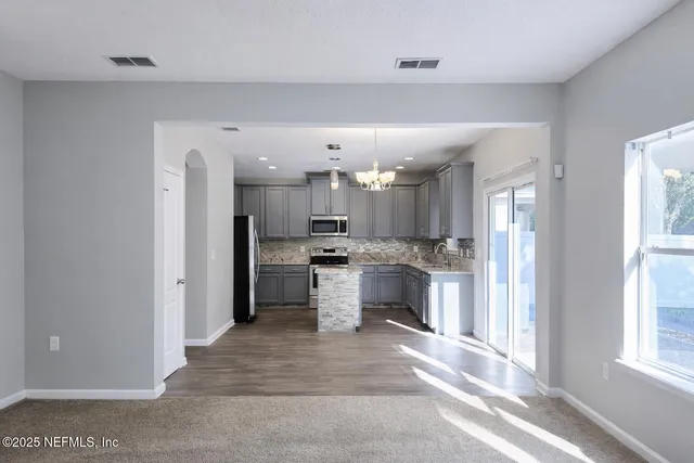 a view of a kitchen with a sink and a refrigerator
