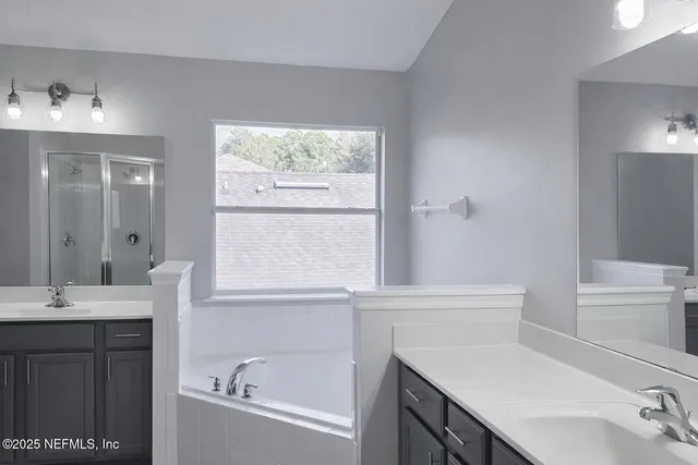 a bathroom with a bathtub sink and mirror