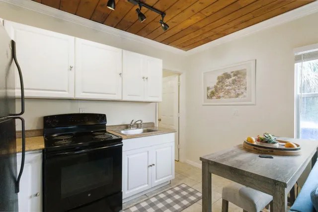 a kitchen with stainless steel appliances a stove a sink cabinets and a dining table