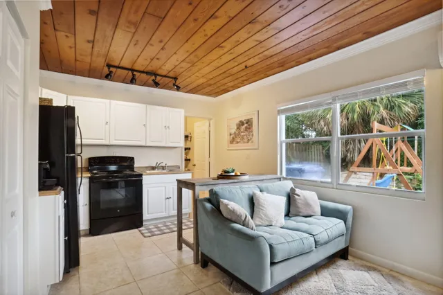 a living room with stainless steel appliances granite countertop furniture a fireplace and a window