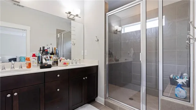 a bathroom with a double vanity sink mirror and shower