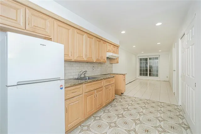 a kitchen with a refrigerator sink and cabinets