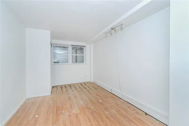 a view of a room with wooden floor and white walls