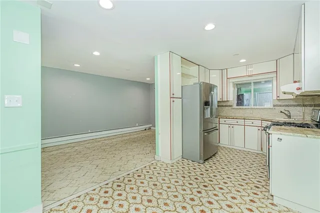 a kitchen with a refrigerator sink and cabinets