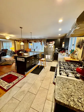 a kitchen with stainless steel appliances kitchen island granite countertop a stove and cabinets