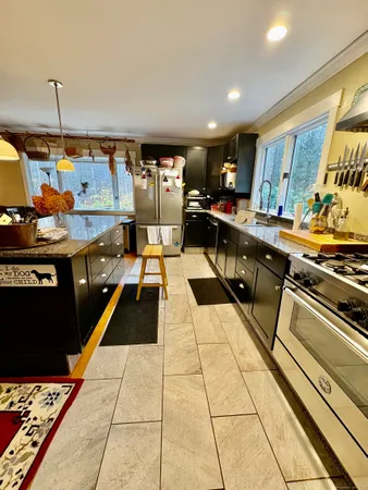 a kitchen with stainless steel appliances kitchen island granite countertop a stove a sink and a microwave