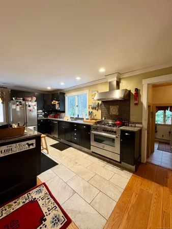 a kitchen with stainless steel appliances kitchen island granite countertop a refrigerator and a stove top oven