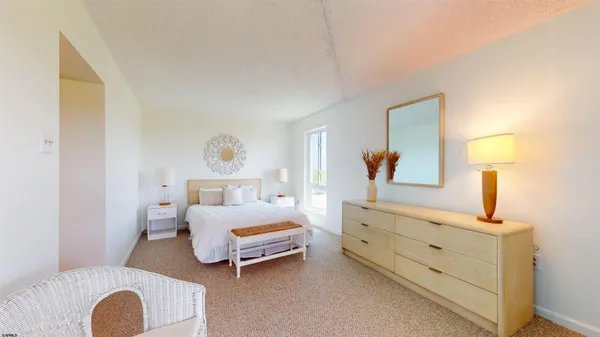 a bedroom with a bed and a lamp on dresser