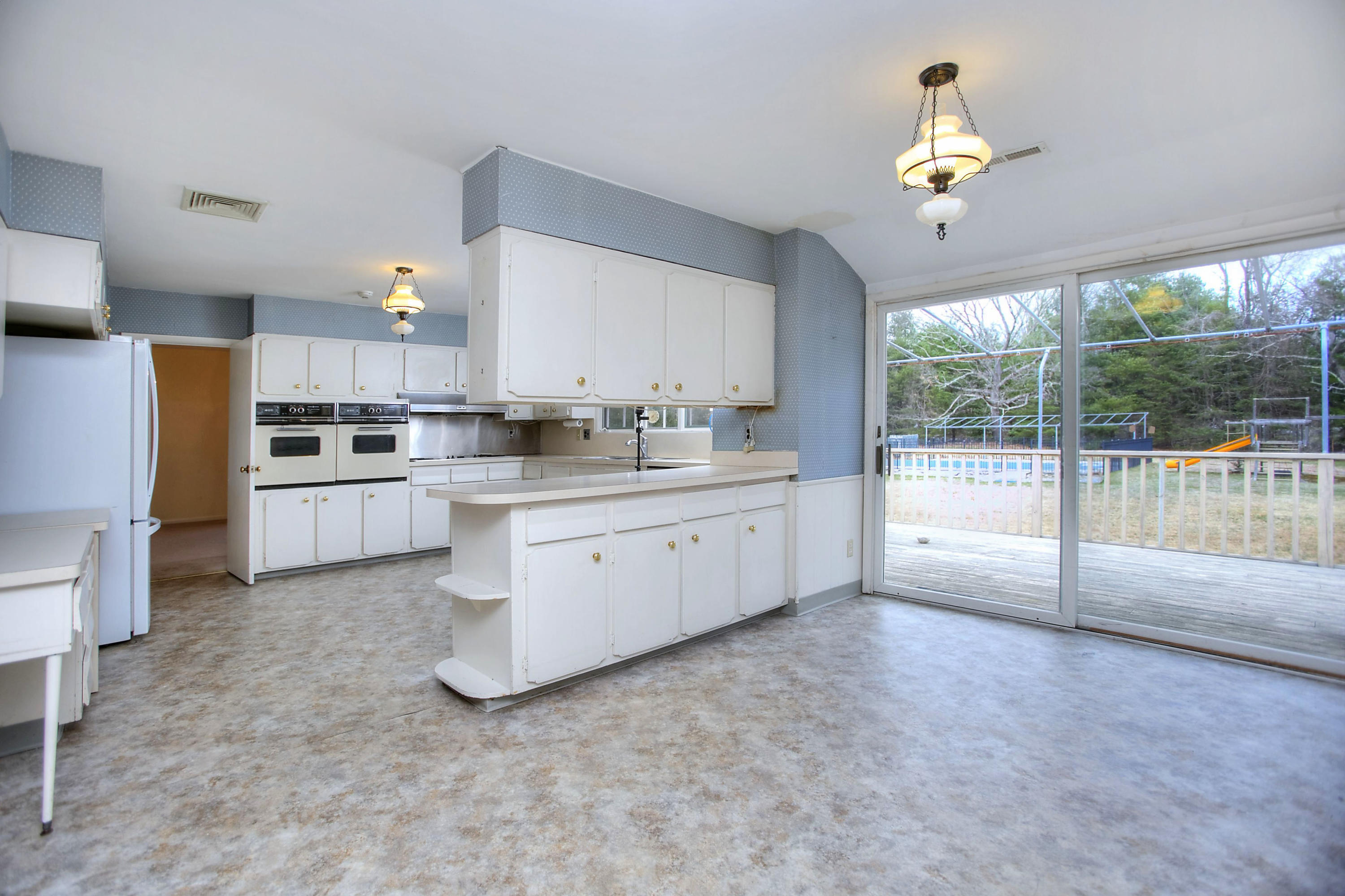 853 Valley Road New Canaan, CT 06840 - Photo 8 of 30 a kitchen with stainless steel appliances a sink a stove a refrigerator cabinets and a window