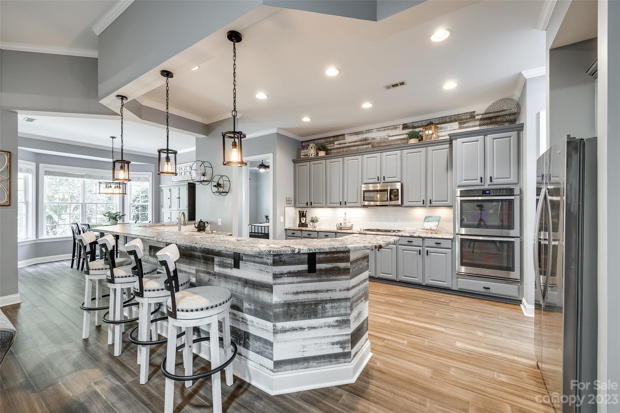 675 Quicksilver Trail Fort Mill, SC 29708 - Photo 14 of 48 a kitchen with stainless steel appliances kitchen island granite countertop a table chairs and a refrigerator