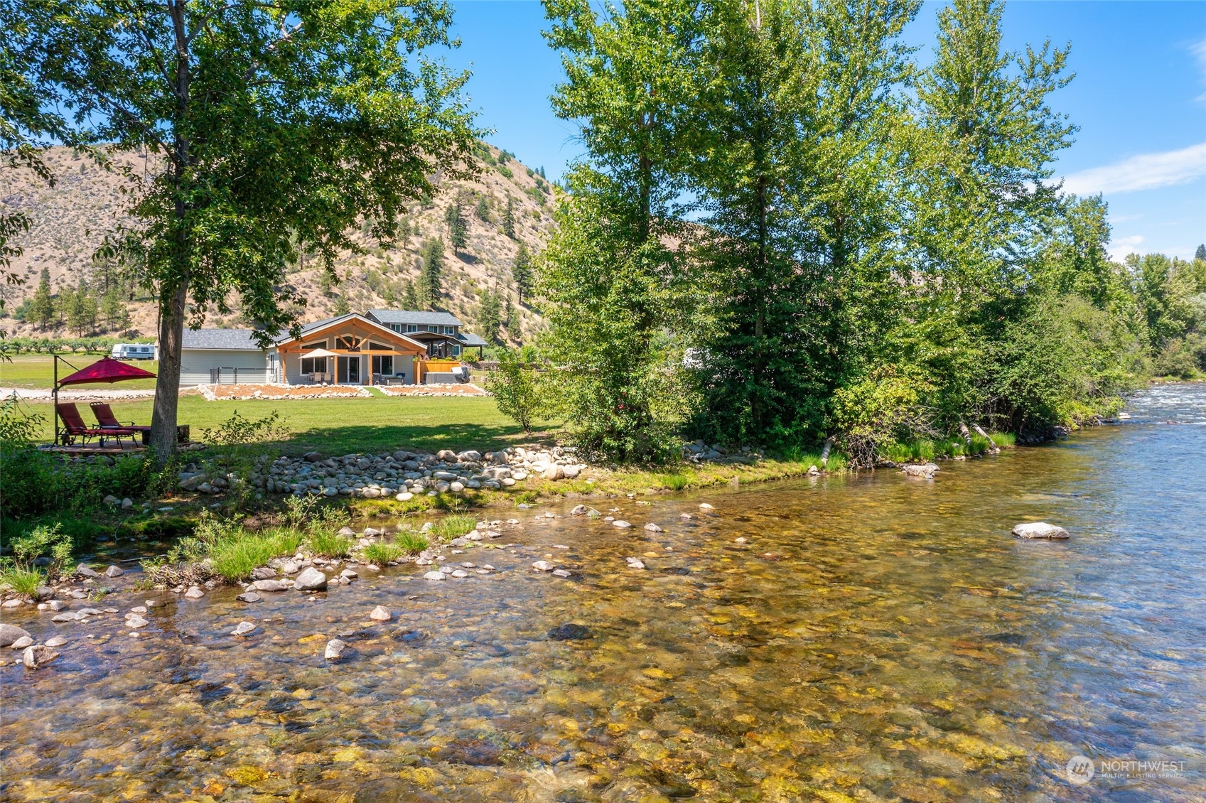 a front view of a house with a yard and lake view