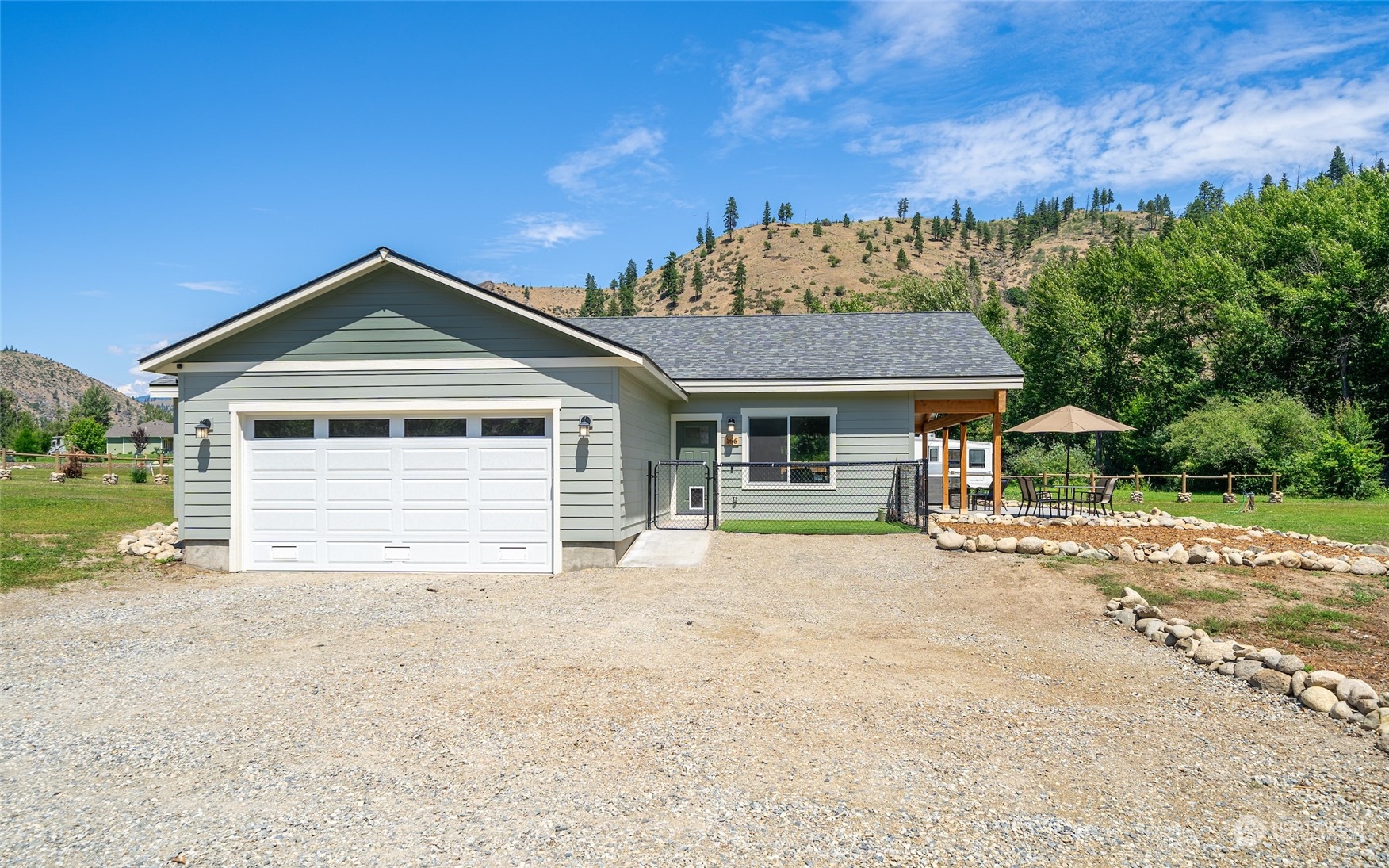 166 Mad River Road Entiat, WA 98822 - Photo 11 of 40 a front view of a house with a yard and garage