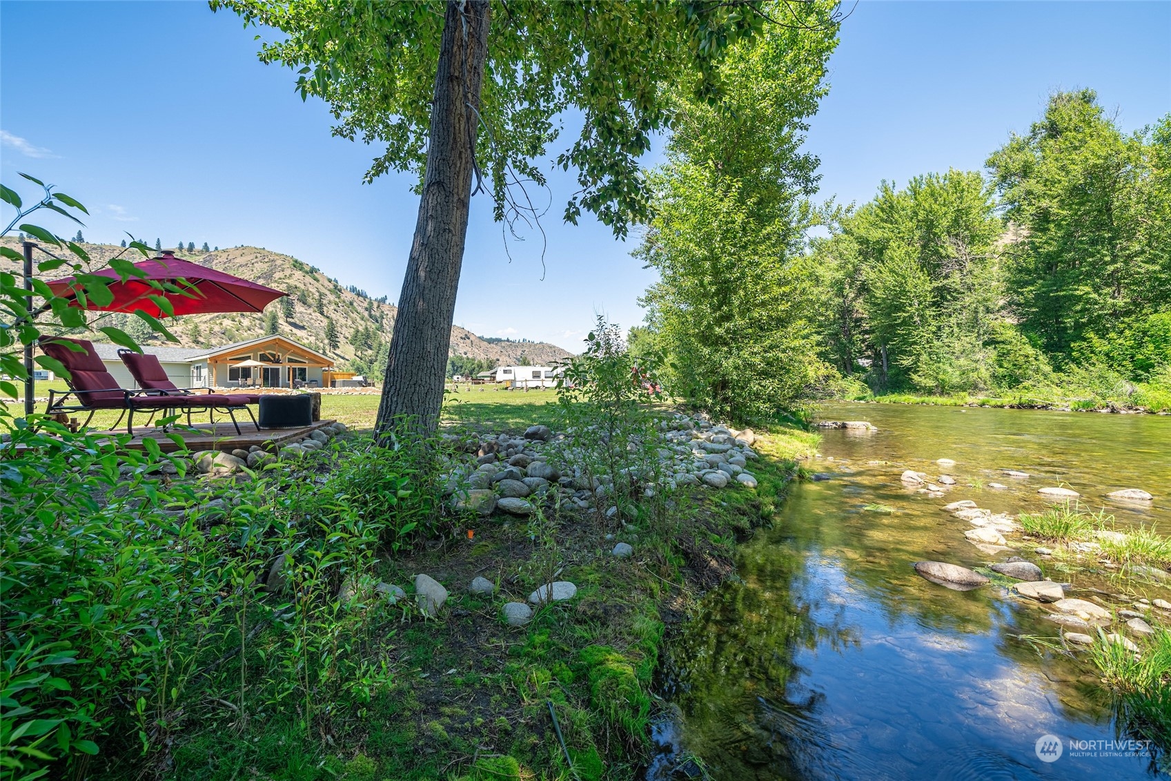 166 Mad River Road Entiat, WA 98822 - Photo 6 of 40 a backyard of a house with lots of green space and fountain