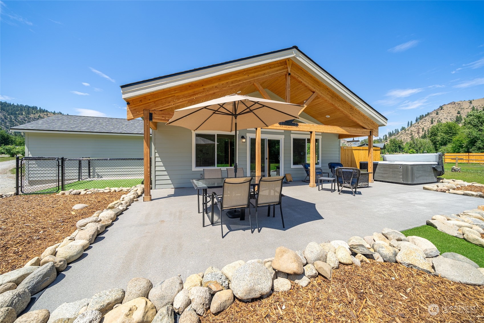 166 Mad River Road Entiat, WA 98822 - Photo 9 of 40 a patio with a table and chairs under an umbrella