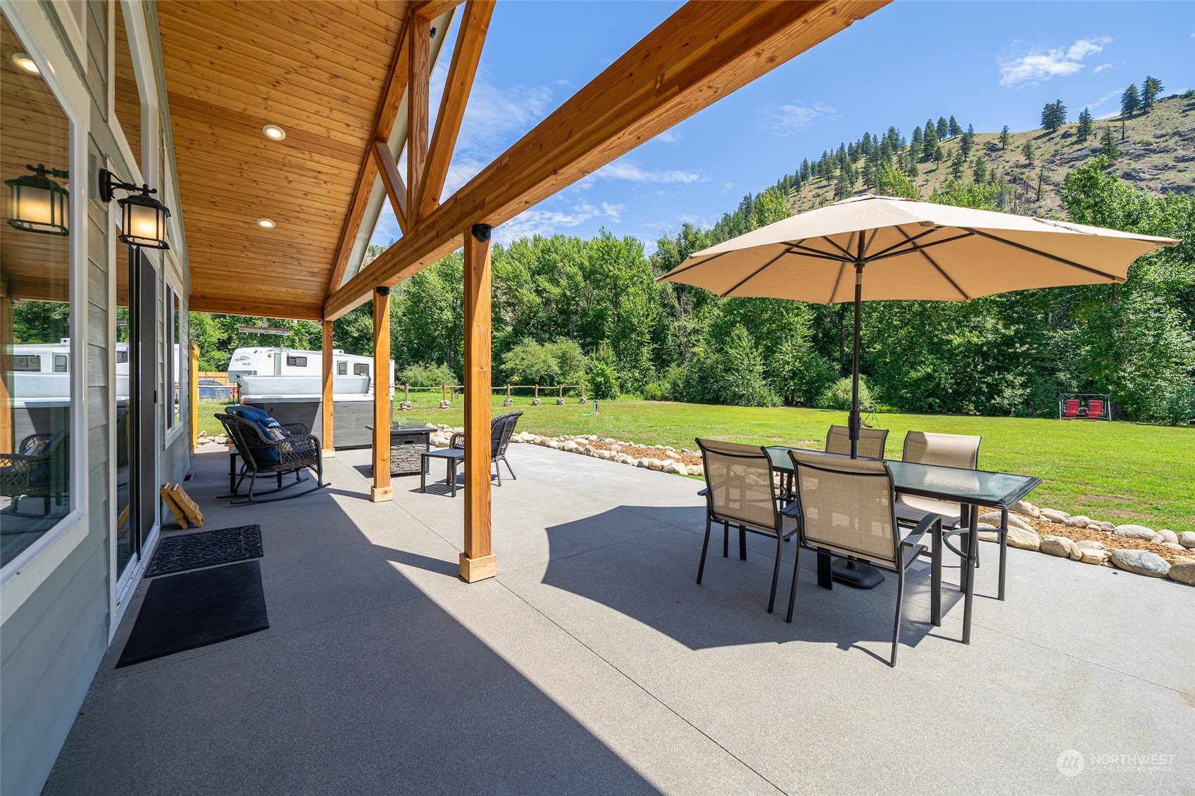 166 Mad River Road Entiat, WA 98822 - Photo 10 of 40 a view of a patio with a table and chairs under an umbrella