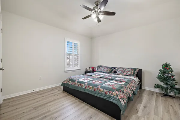a bedroom with a bed and a potted plant