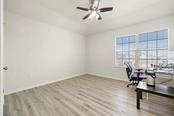 a view of a workspace with wooden floor and a window