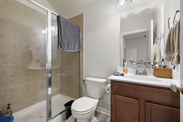 a bathroom with a sink a toilet and shower