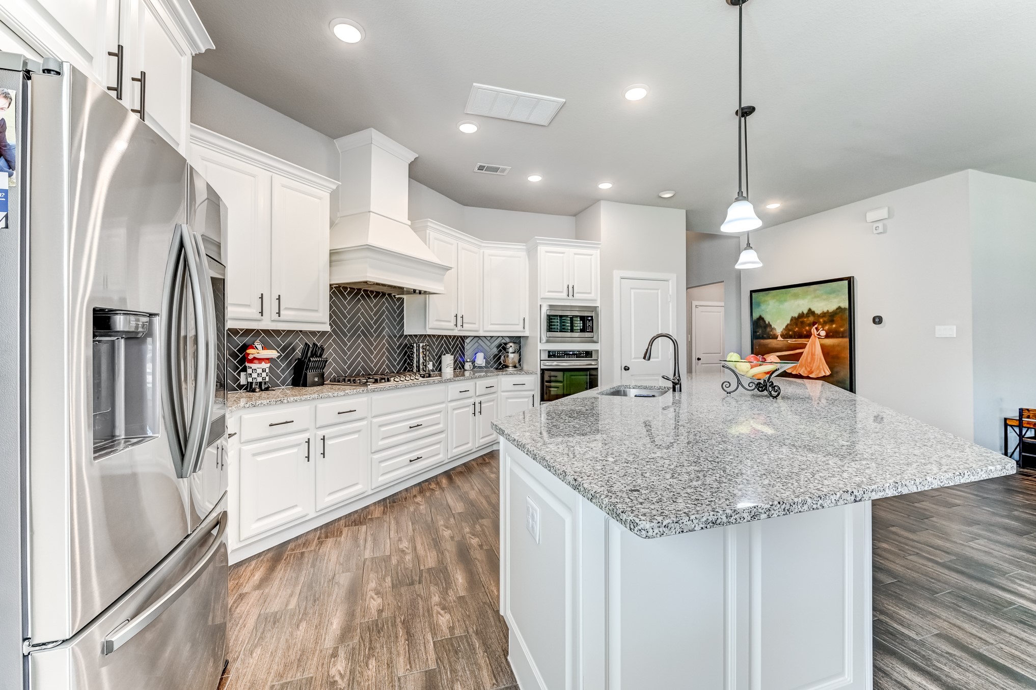 404 Summit Ridge Court Conroe, TX 77318 - Photo 12 of 50 a kitchen with stainless steel appliances granite countertop a sink refrigerator and cabinets