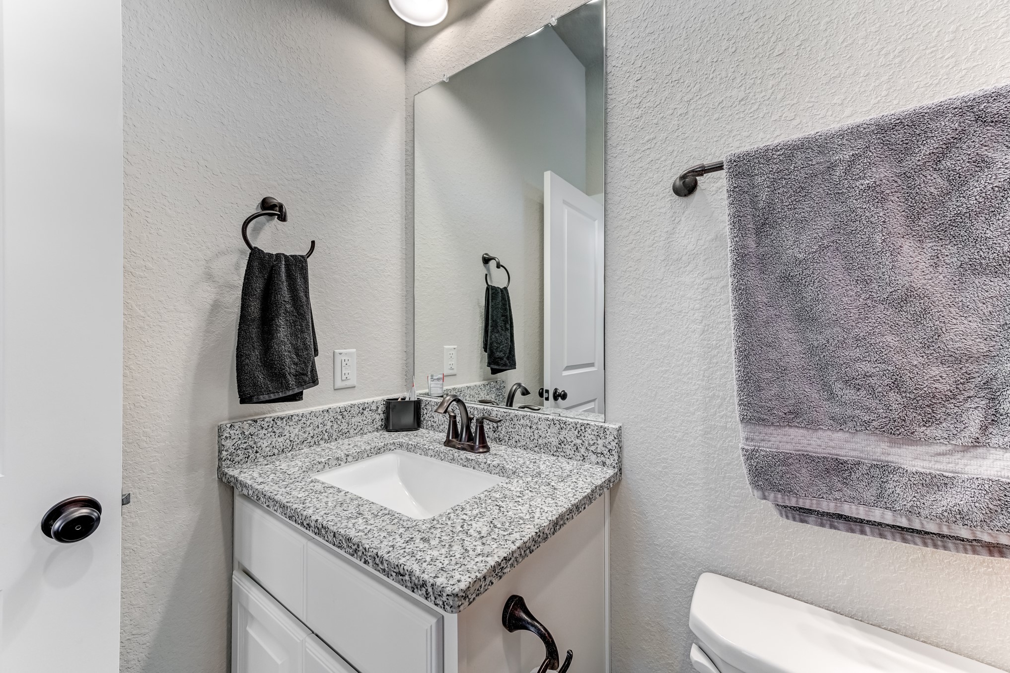 404 Summit Ridge Court Conroe, TX 77318 - Photo 25 of 50 a bathroom with a granite countertop sink and a mirror
