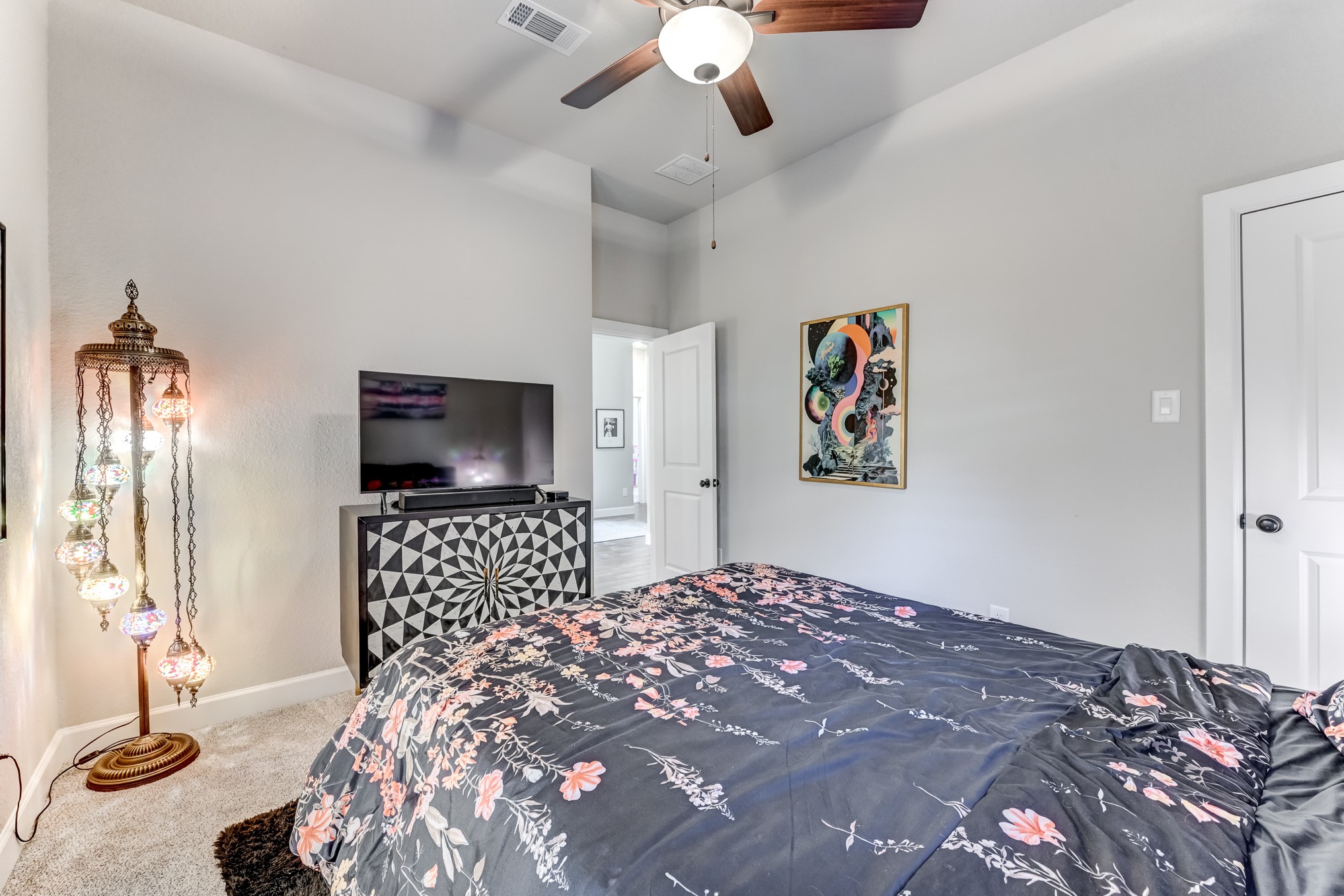 404 Summit Ridge Court Conroe, TX 77318 - Photo 28 of 50 a bedroom with a large bed and a chandelier