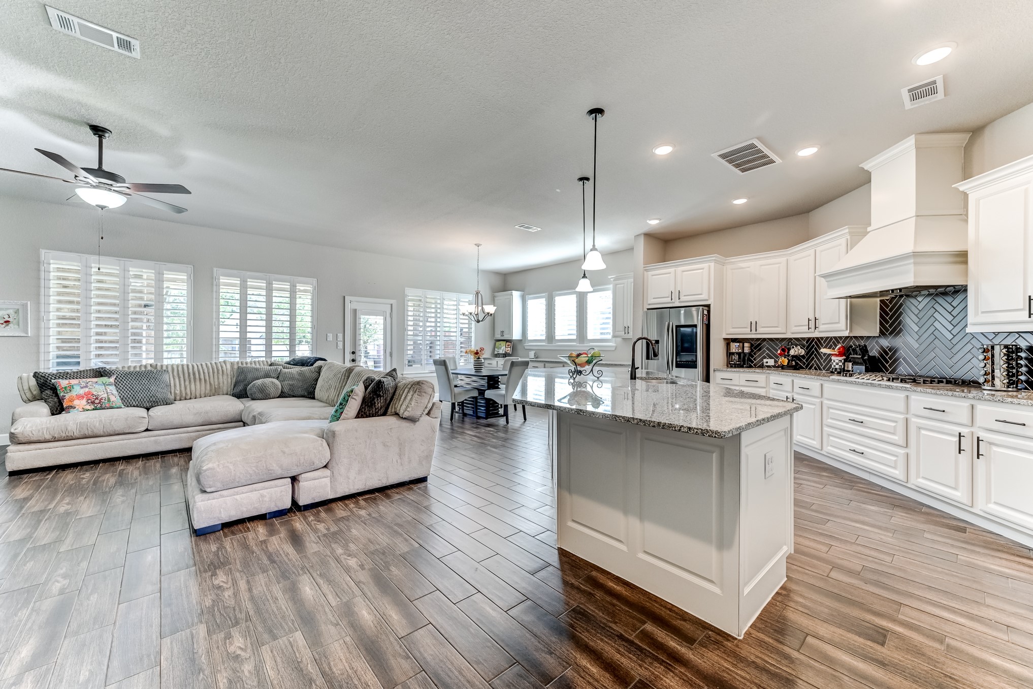 404 Summit Ridge Court Conroe, TX 77318 - Photo 9 of 50 a living room with couches and kitchen view with wooden floor