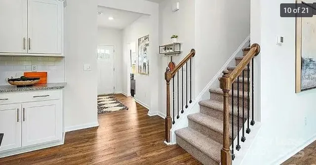 a view of entryway and kitchen with wooden floor